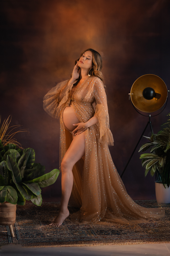 Foto maternità profilo - Donna incinta accarezza il pancione in abito champagne, servizio fotografico Trieste