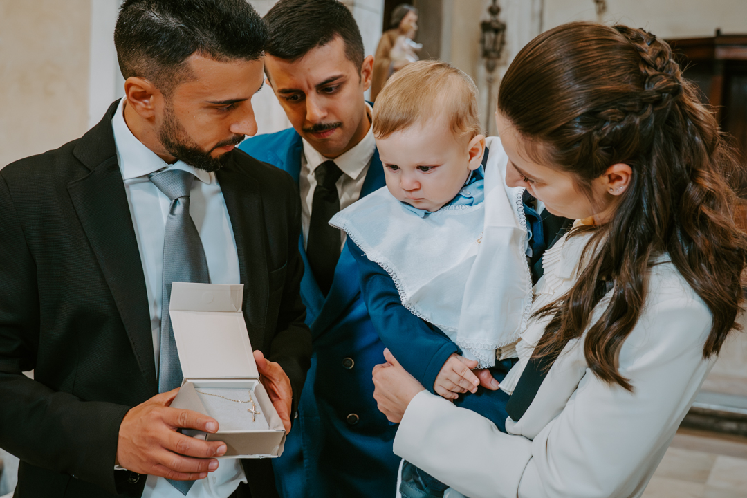 Servizio fotografico battesimo famiglia Trieste - ritratto genitori con bambino all'esterno chiesa