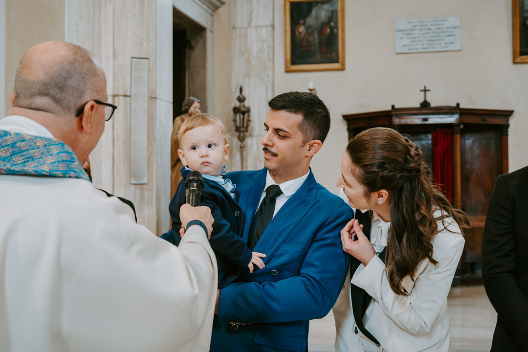Servizio fotografico battesimo famiglia Trieste - ritratto genitori con bambino all'esterno chiesa